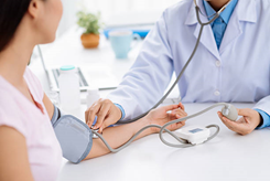 Woman blood pressure check white coat doctor